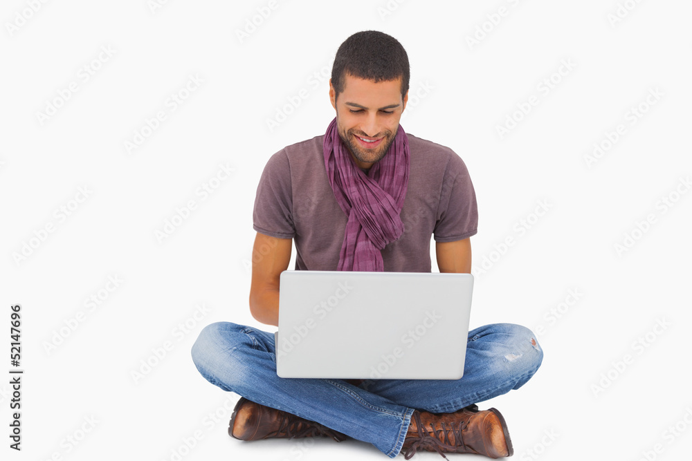 Stylish man sitting on floor using laptop Stylish man sitting on floor using laptop