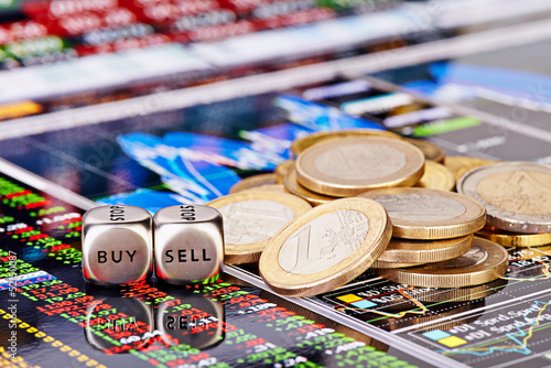 Dices cubes with the words SELL BUY, one-euro coins and a financ