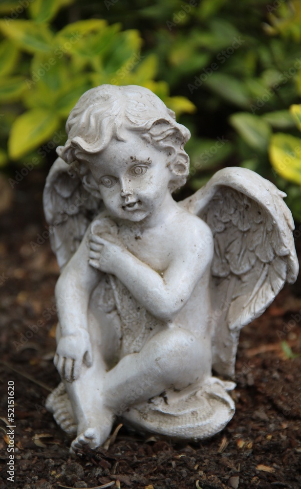Ein Engel sitzt auf einem Grab
