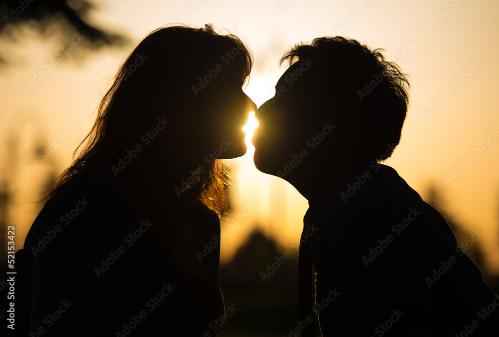 Romantic couple kissing at sunset