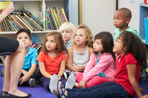 Elementary Pupils In Classroom Working With Teacher