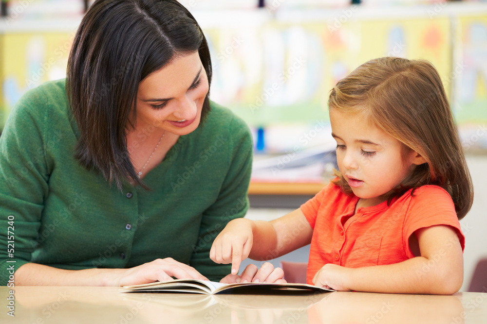 Elementary Pupil Reading With Teacher In Classroom Elementary Pupil Reading With Teacher In Classroom