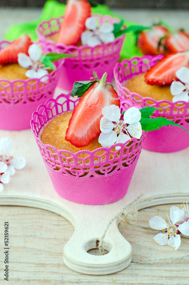 Muffins with strawberries on a wooden table Muffins with strawberries on a wooden table