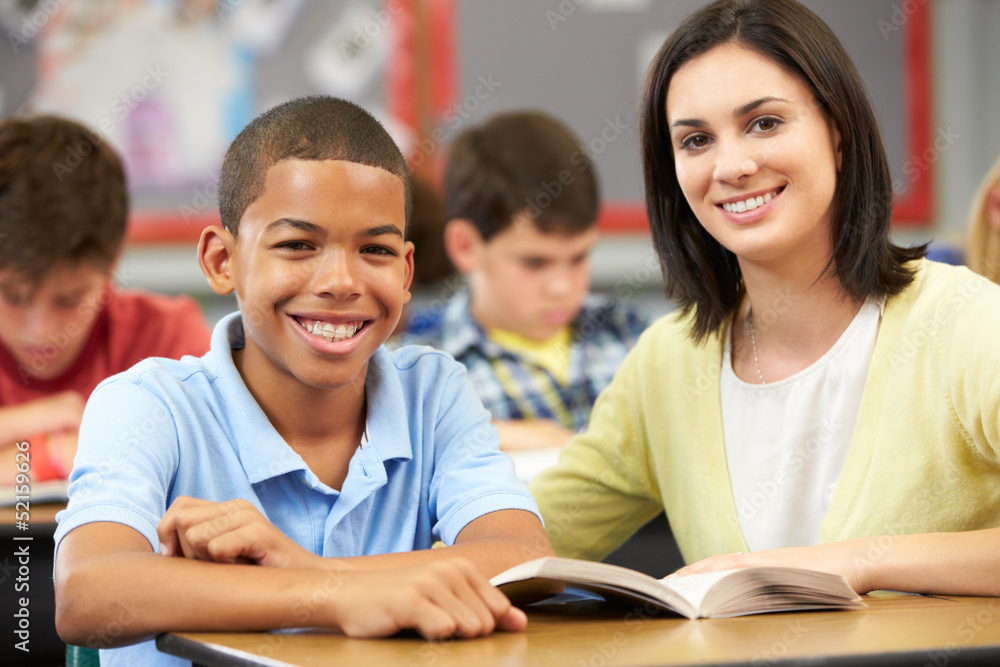 Teacher Reading With Male Pupil In Class Teacher Reading With Male Pupil In Class