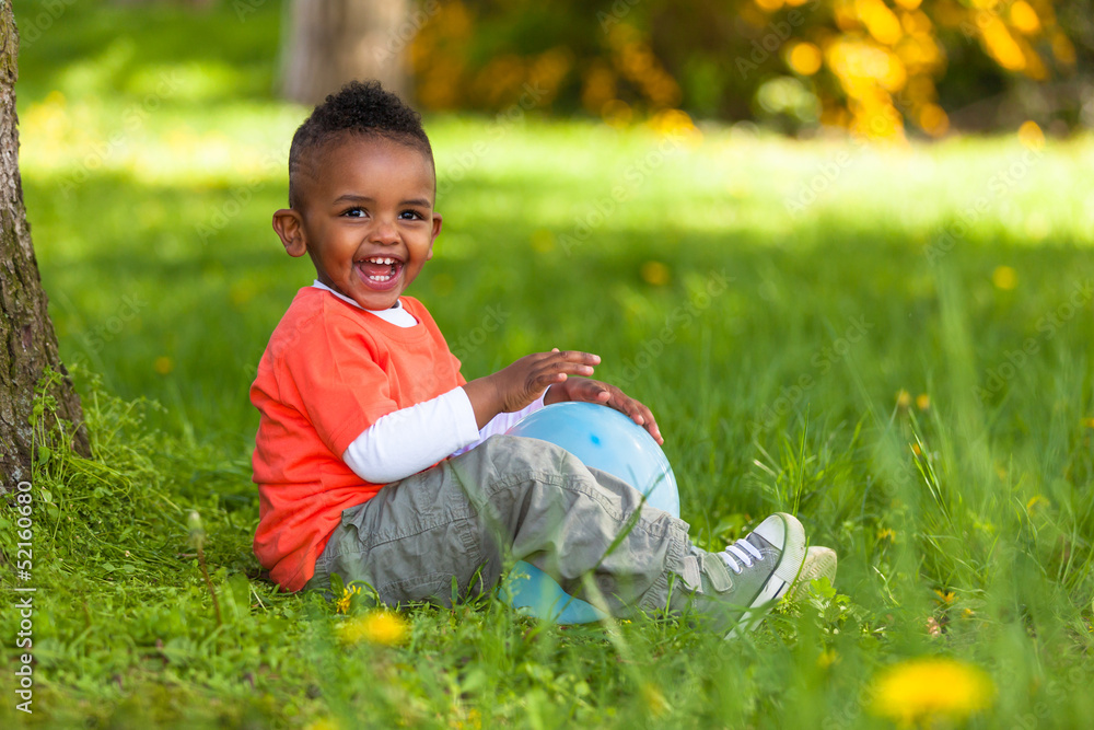 Outdoor portrait of a cute young little black boy playing with Stock ...