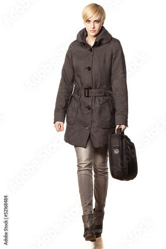 pretty business woman  in a coat carrying a laptop bag