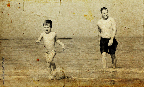 father and son going to swim in the sea. Photo in old image styl