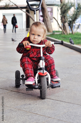 baby on her  tricycle