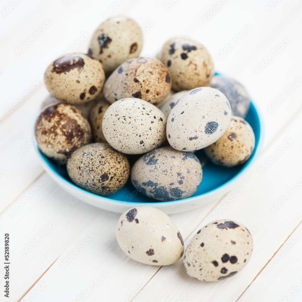 Saucer full of raw quail eggs, close-up, studio shot Saucer full of raw quail eggs, close-up, studio shot