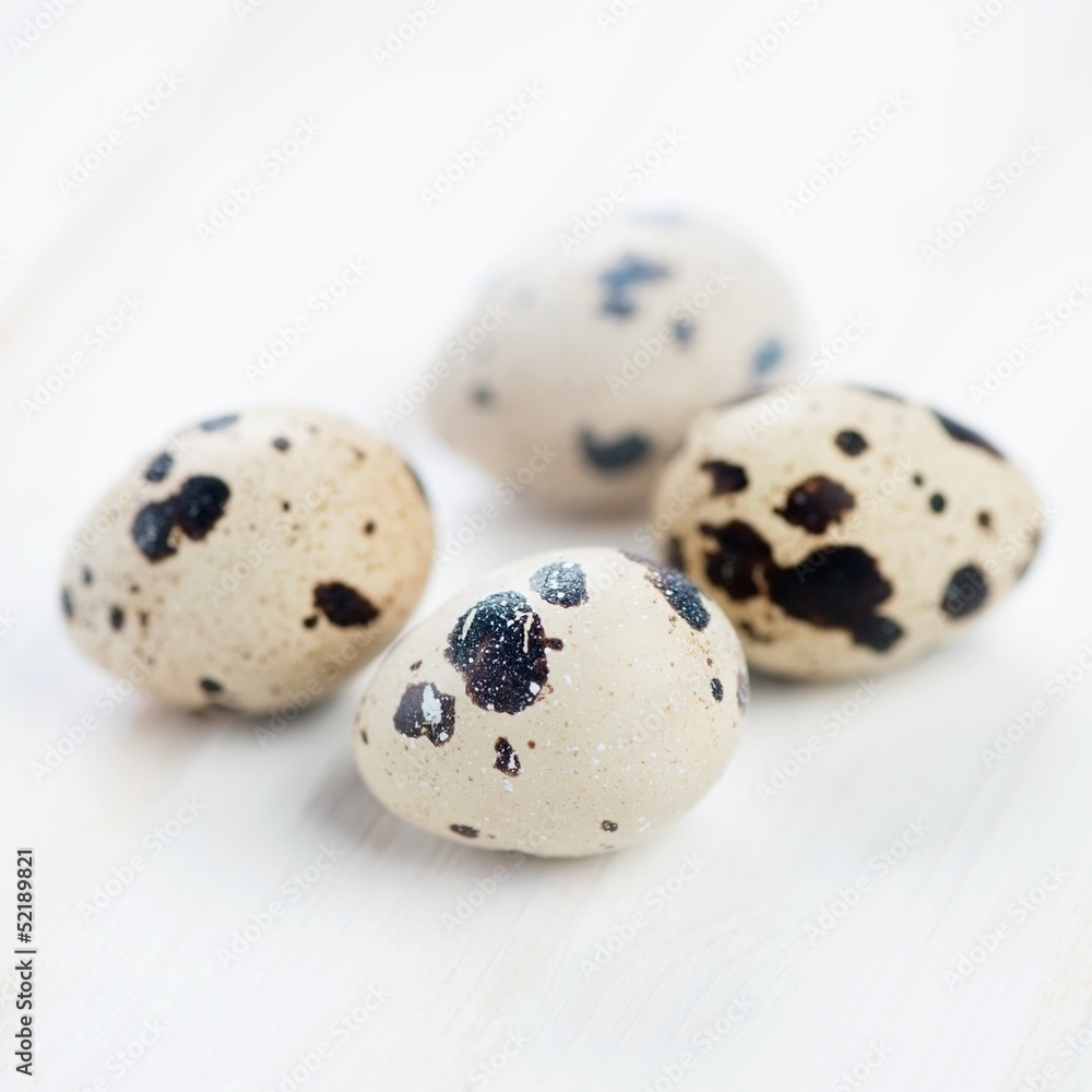 Raw quail eggs on wooden boards, studio shot Raw quail eggs on wooden boards, studio shot