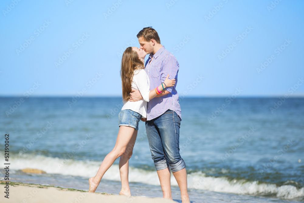 Portrait of young man and woman kissing on a beach