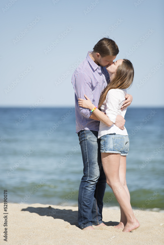 Portrait of young man and woman kissing on a beach Portrait of young man and woman kissing on a beach
