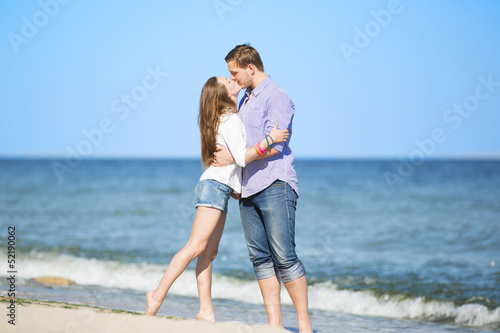 Portrait of young man and woman kissing on a beach