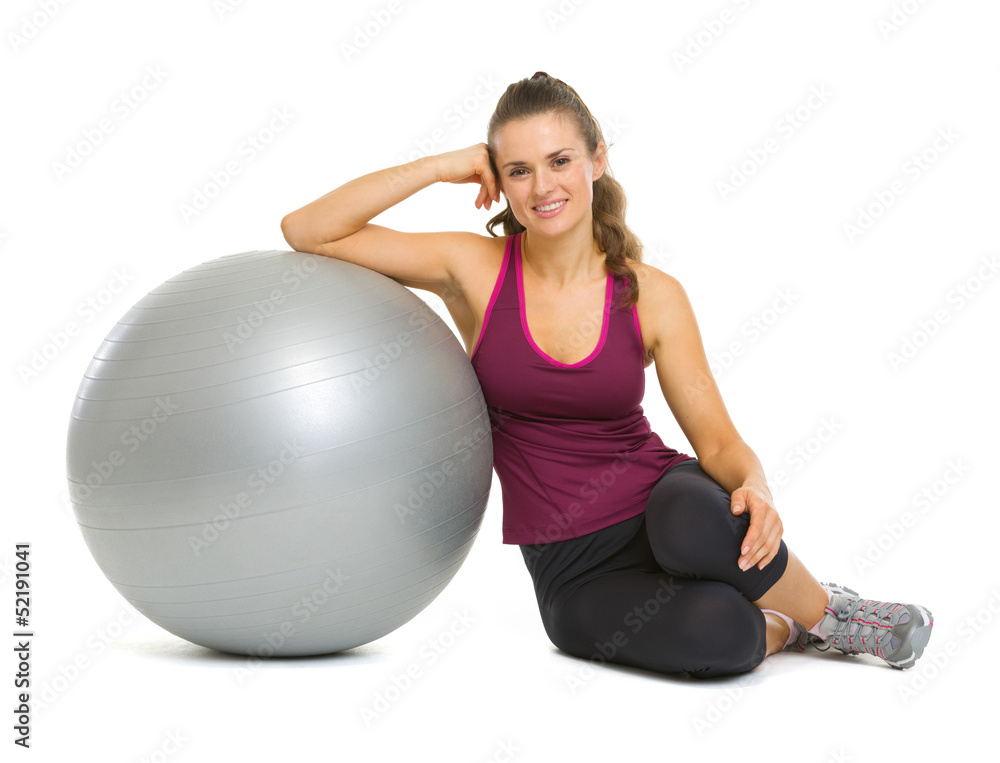 Happy fitness young woman sitting near fitness ball Happy fitness young woman sitting near fitness ball