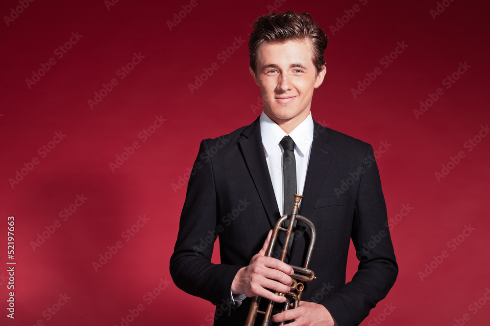 Fototapeta premium Retro fifties trumpet player wearing black suit. Holding his tru