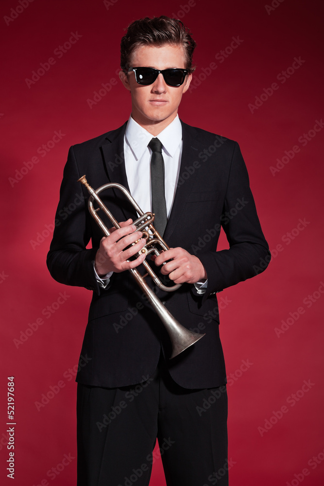 Fototapeta premium Retro fifties trumpet player wearing black suit and sunglasses.