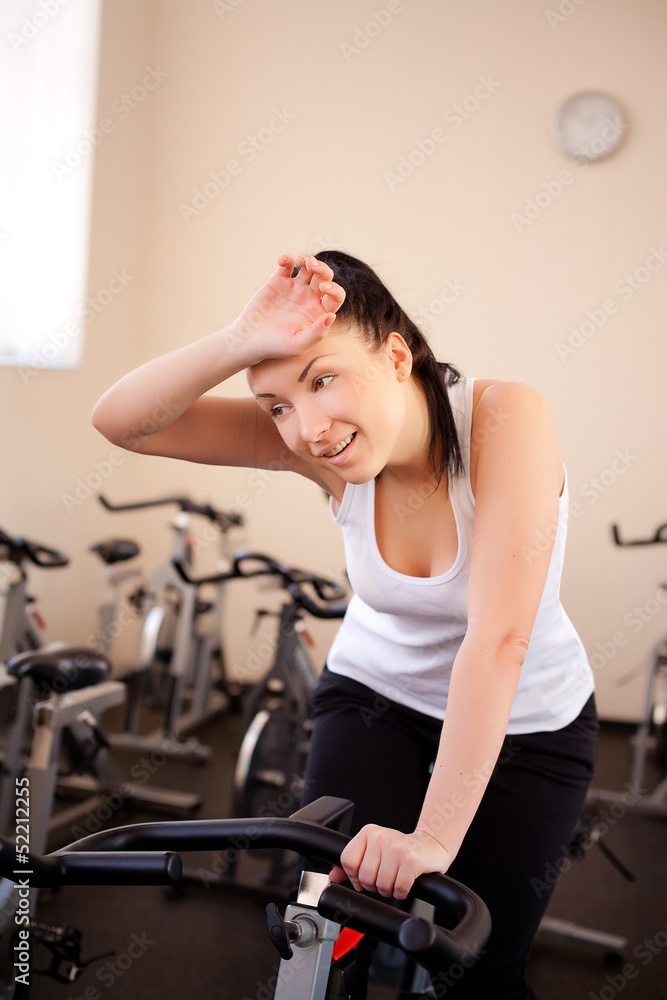 beautiful woman on an exercise bike at the gym beautiful woman on an exercise bike at the gym