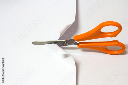 Scissor cutting white paper