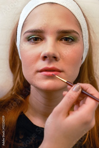 Young woman getting beautiful makeup