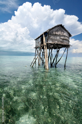 Bajau fisherman's wooden hut on sea water with blue sky