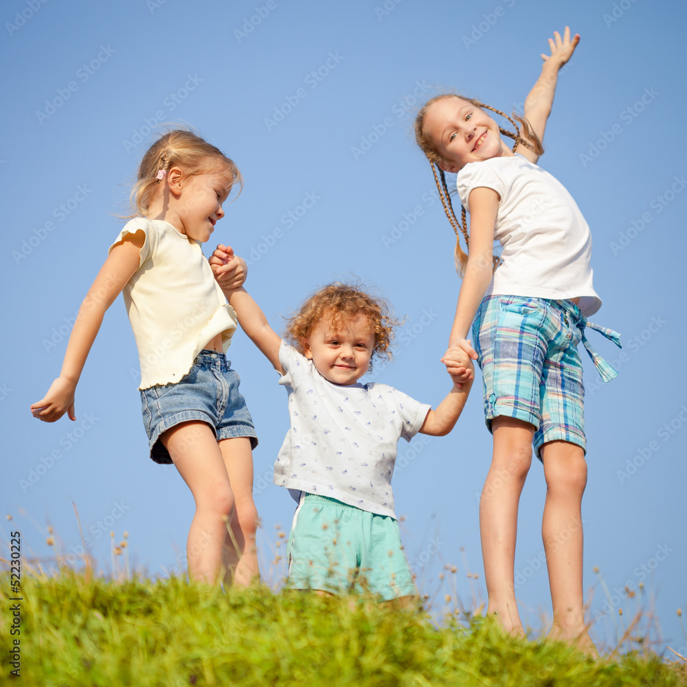 Fototapeta premium two little girls and little boy dancing on the road