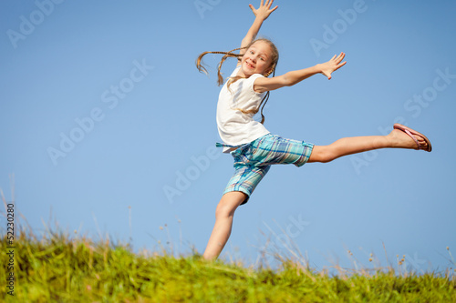 little girl jumping over the grass © altanaka