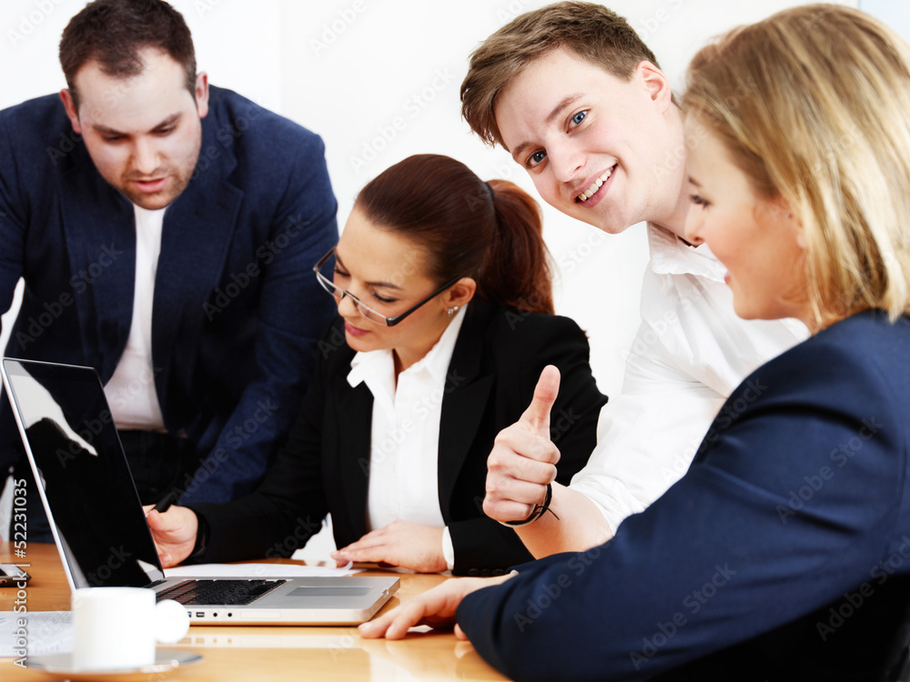 Business people are in a meeting, one shows thumb up Business people are in a meeting, one shows thumb up