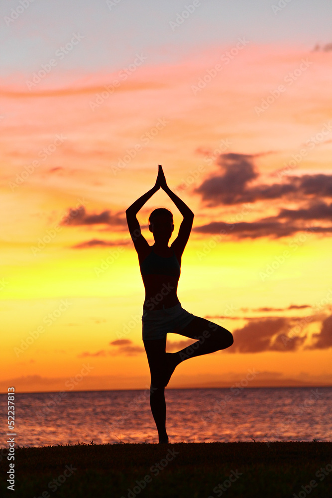 Yoga woman training in sunset in tree pose