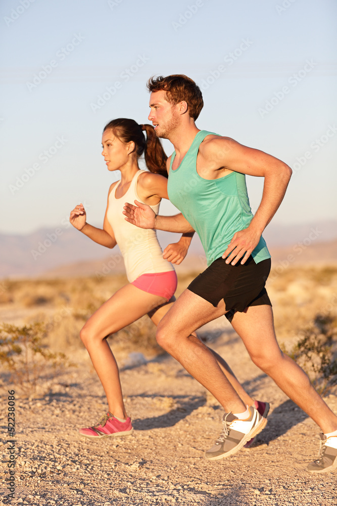 Runners couple running in trail run outside Runners couple running in trail run outside