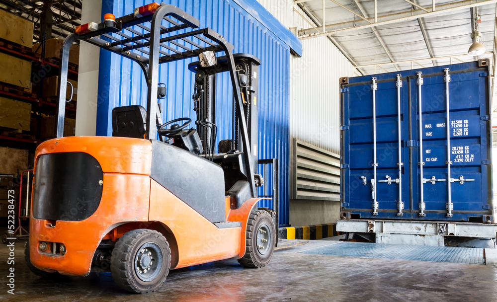 Forklift in warehouse with container