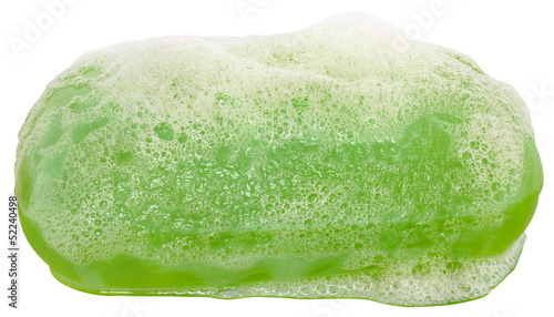 Bar of green soap in the foam close up.