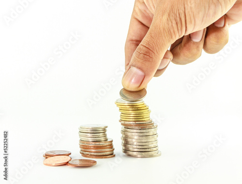 Stack of coins with hand on