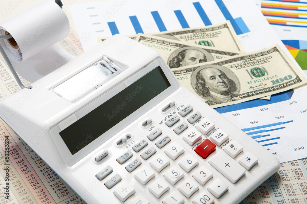 Calculator and diagrams and money on a business background Calculator and diagrams and money on a business background
