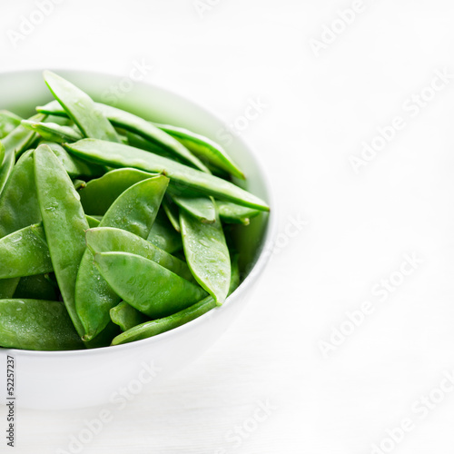 Snow peas in white bowl with copy space