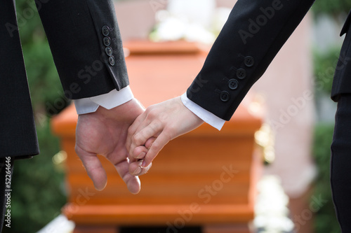 People at funeral consoling each other photo