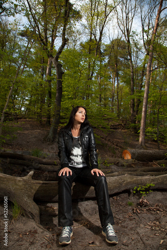 junge Frau sitzt im Wald und entspannt