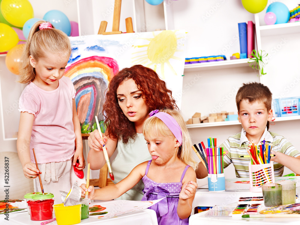 Fototapeta premium Child painting at easel.