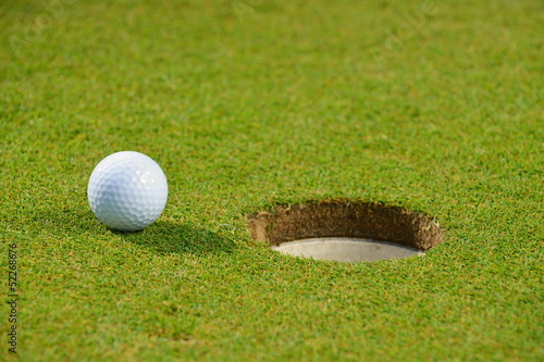 Golf ball on lip of cup