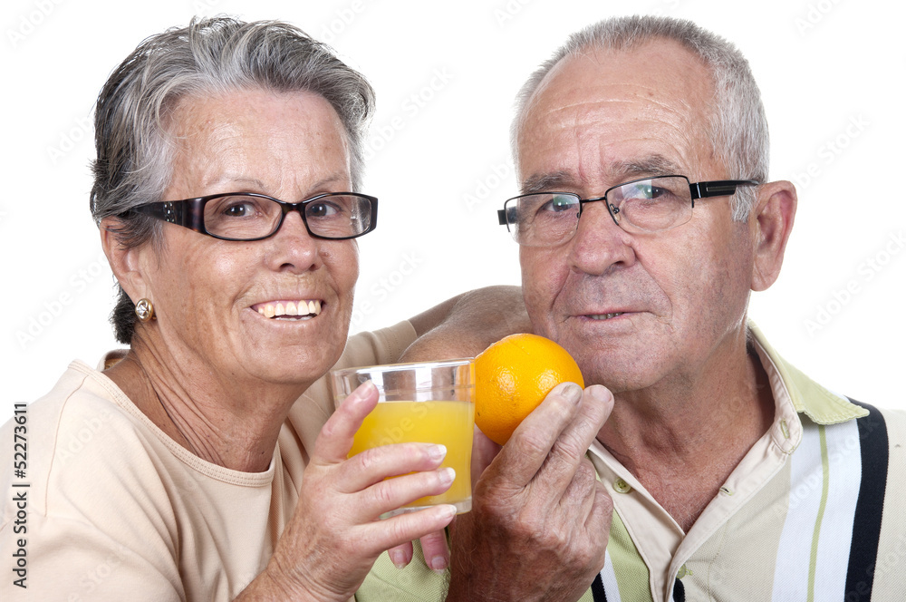 Vieux couple tenant dans la main un verre de jus d'orange et une Vieux couple tenant dans la main un verre de jus d'orange et une