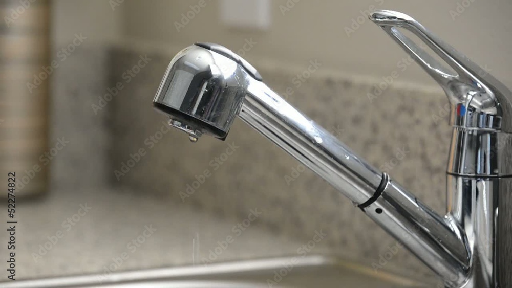 Close up dripping kitchen sink faucet, slow motion, overcranked Close up dripping kitchen sink faucet, slow motion, overcranked