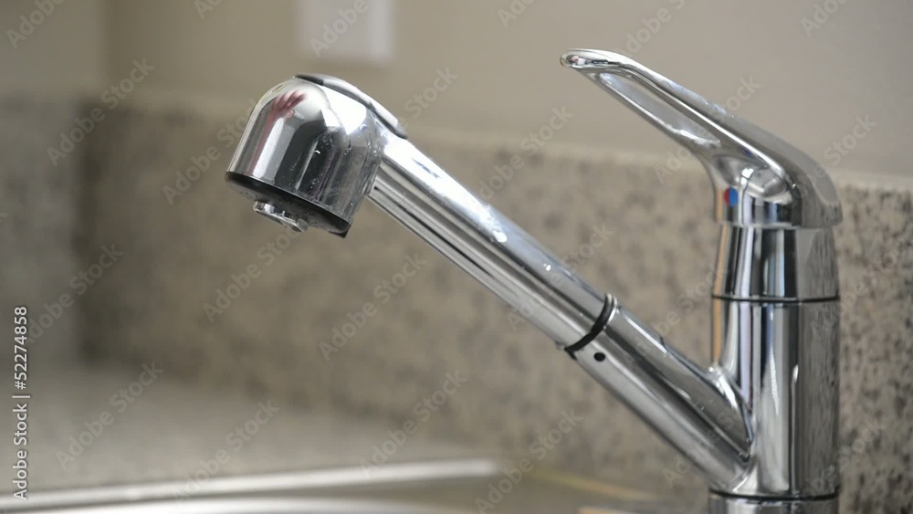 Close up of man turning off dripping kitchen sink faucet Close up of man turning off dripping kitchen sink faucet