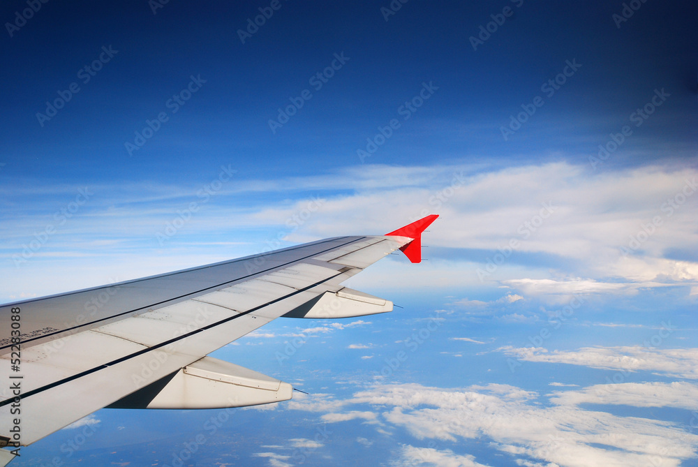 Fototapeta premium Wing of the plane on sky background