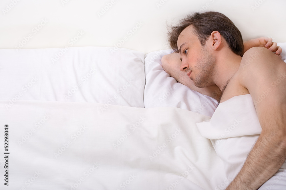 Upset man lies in the bed Upset man lies in the bed