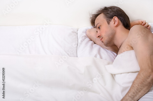 Upset man lies in the bed