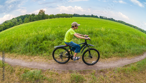 landscape through fish eye lens with boy racing on bike