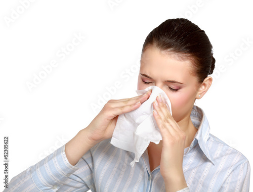 A portrait of a young woman blowing her nose