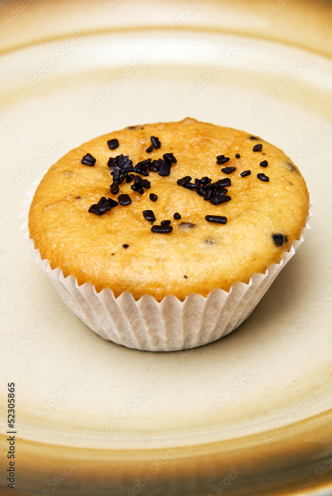 Freshly baked muffins in cups topped with chocolate . Freshly baked muffins in cups topped with chocolate .