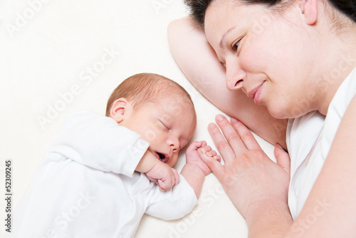 mother watching her month old son sleeping in bed