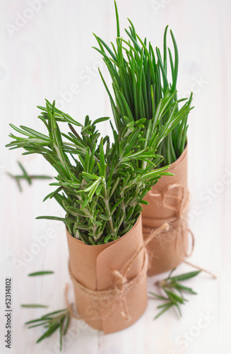 bunch of fresh rosemary and chives on wooden table