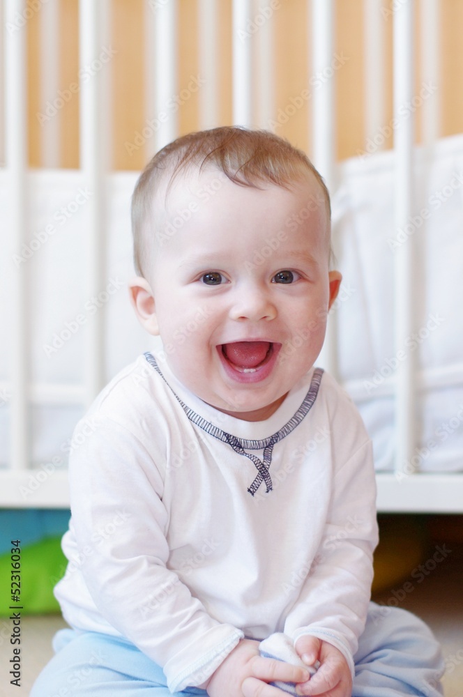 happy smiling baby against white bed